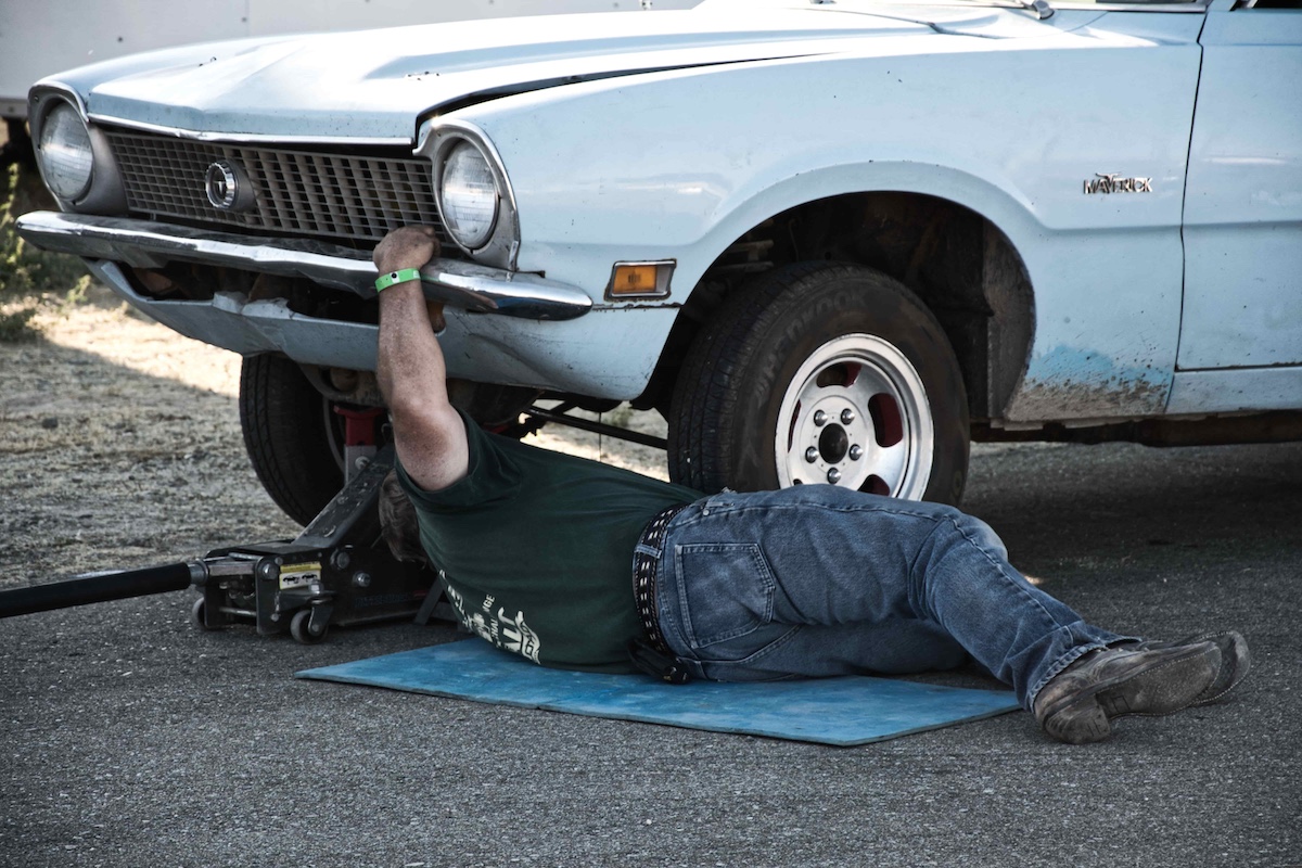 Mobile mechanic working under the hood of a car in a Radcliff Kentucky driveway